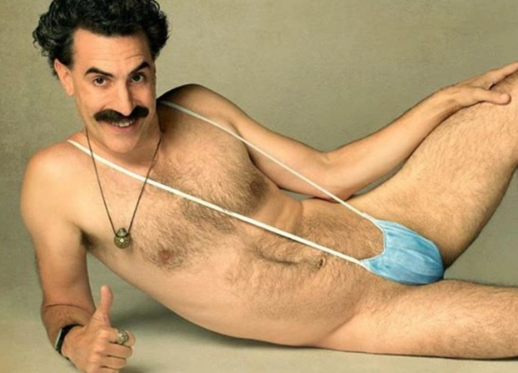 <em>Borat 2</em> Bus Poster Sparks Outrage As Actor Seen Wearing “Allah” Ring And Mankini